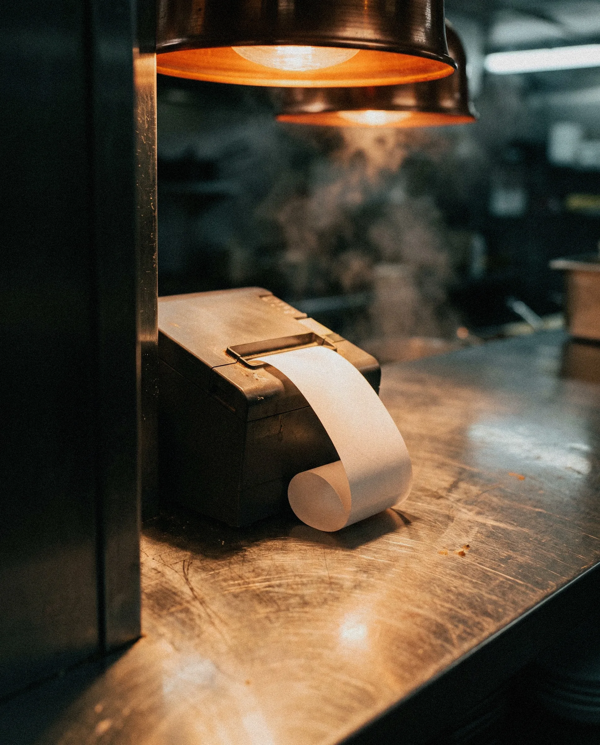 A kitchen ticket printer at a restaurant pass.